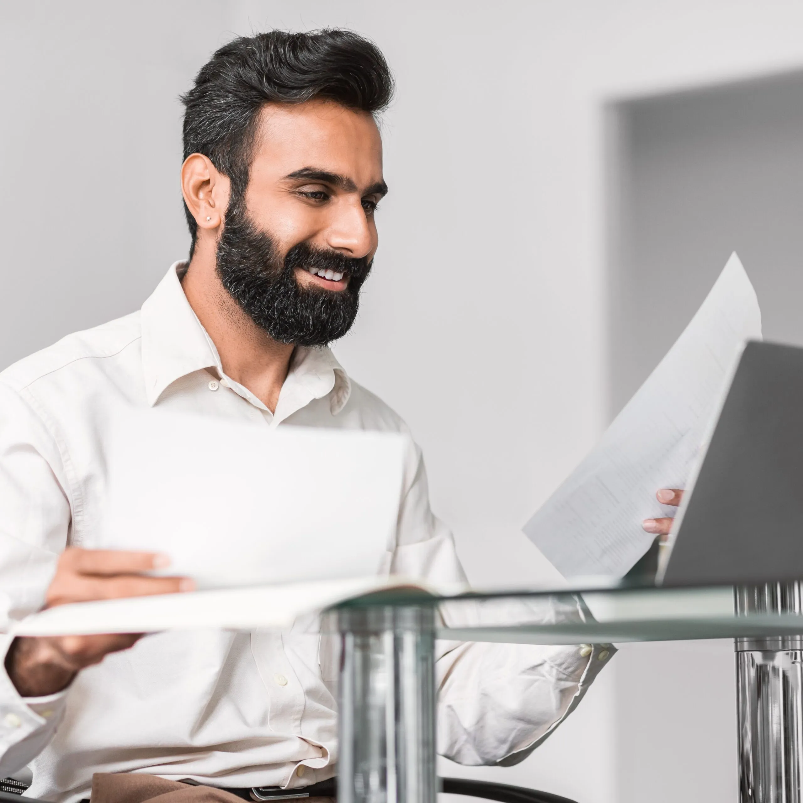Cheerful indian professional reading documents with a smile