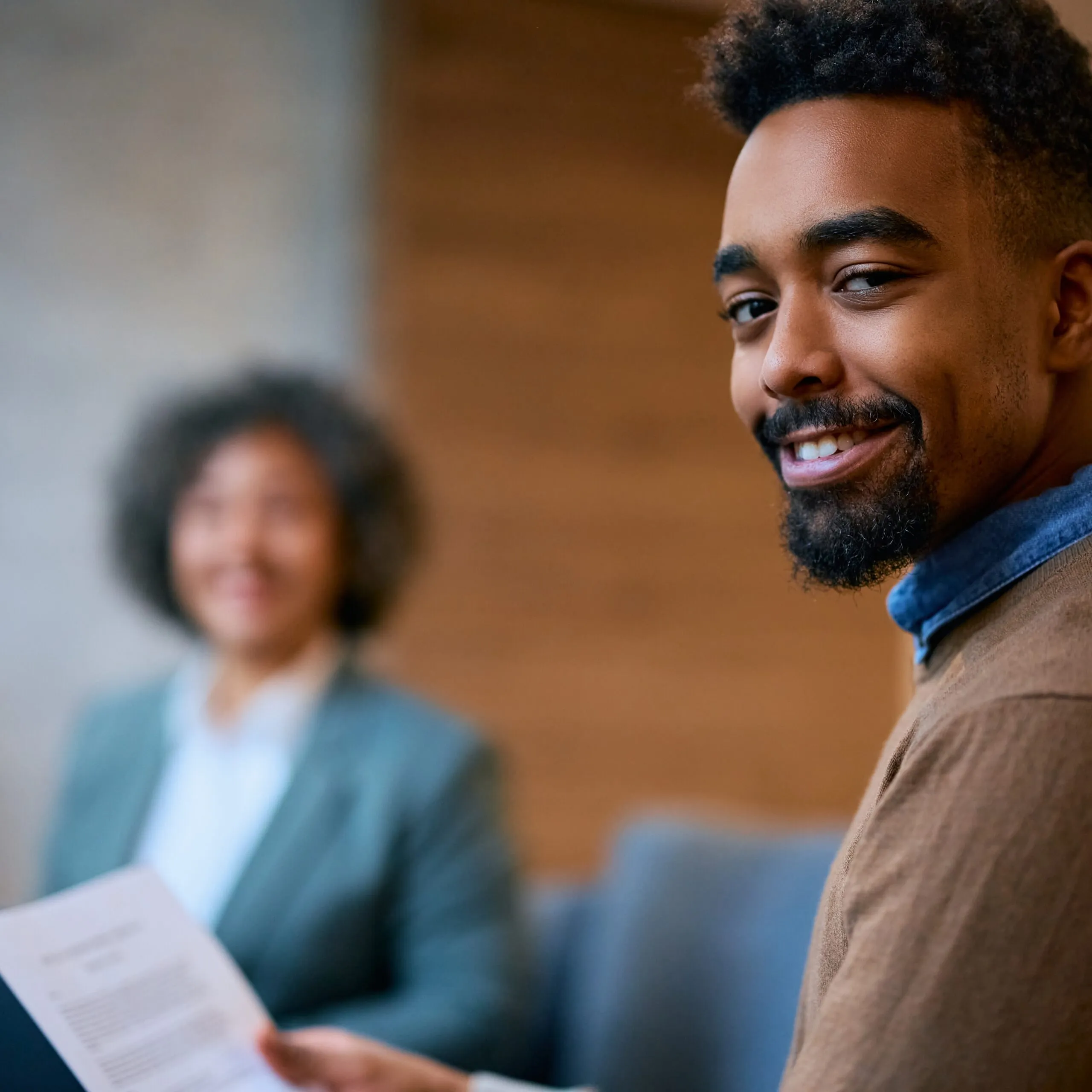 Happy black man on a meting with financial advisor looking at camera.