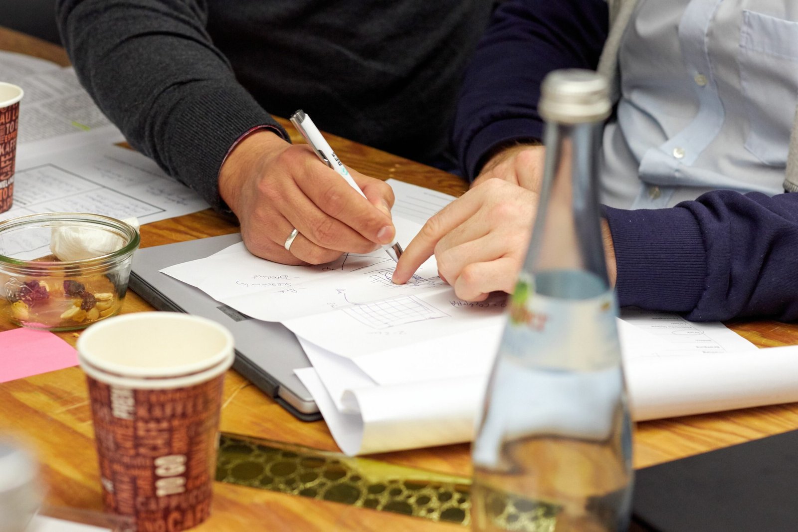 Man writing on a white paper during a meeting