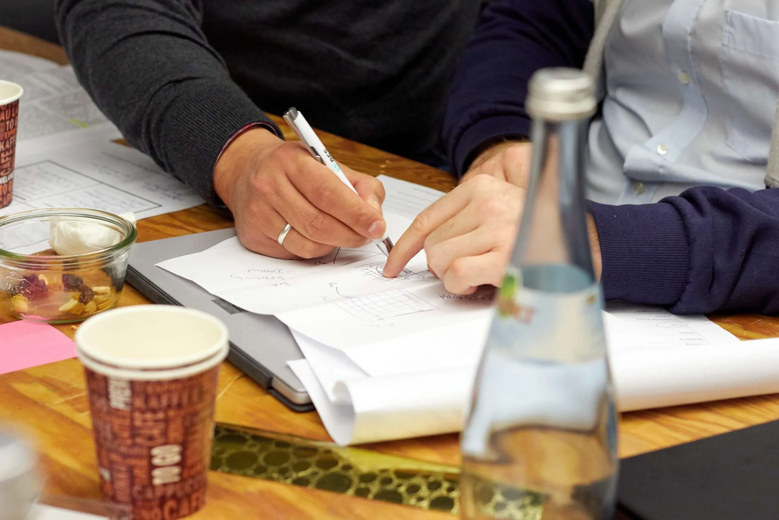 Man writing on a white paper during a meeting Man writing on a white paper during a meeting